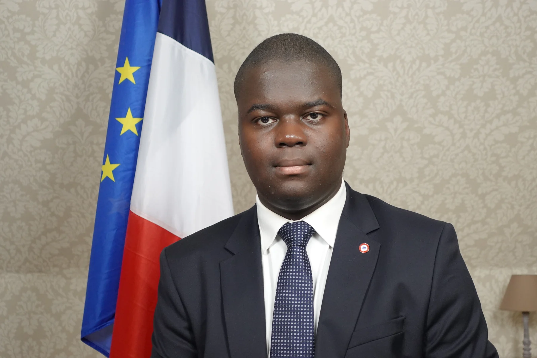 Portrait de Tanguy David seul devant les drapeaux français et européen